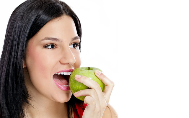 žena jí zelené jablko